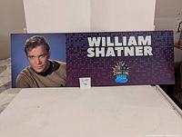 Full view of the large event nameplate featuring William Shatner's name, image, and Comic Con logo.
