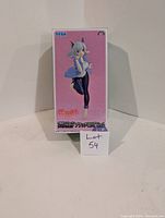 Front view of the boxed statue showing Black Hanekawa in a blue top and black pants on a pink background.