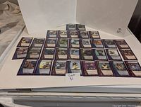 Collection of Marvel RPG game cards arranged in rows on a white surface, each card in a clear protective sleeve.