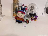 Lot laid out showing all toys including South Park plush, robot figure, Vote for Pedro figure in tube, Raiden Mortal Kombat figure, and small collectible figurines