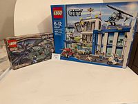 Open box Lego sets including Harry Potter and Lego City Police Station with their boxes showing wear and open edges.