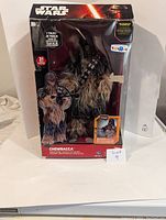 Full view of Chewbacca figure in original box with visible box damage, showing packaging and figure details.
