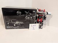 Transformers Masterpiece Prowl figure posed next to original box showing Nissan Fairlady 280Z-2 vehicle mode