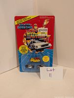 Photo of original blister card packaging showing all three Back to the Future II mini cars sealed inside.