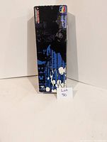 Front and side view of original packaging box with black and blue anime themed graphics and a small sticker indicating 2001 copyright by Sunrise, Bandai and MediCom Toy Corporation.