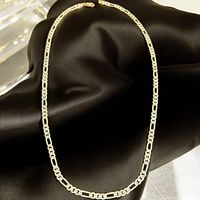 Sterling silver chain necklace displayed on black fabric background showing chain pattern and clasp.