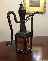 Side view of the vintage Chinese tea pot showing one side panel with traditional figures painted in an inside out style and the bamboo-like handle.