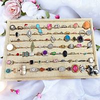 Full tray of 88 assorted vintage/antique costume jewellery rings in various sizes and styles with colorful synthetic stones and metal types.
