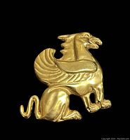 Front view of the gold plated griffin brooch showing detailed design and shape.