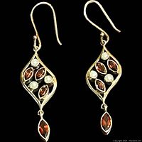 Front view of both drop earrings showing the marquise garnets and pearls set in an open sterling silver leaf-shaped design