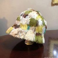 Front view of hat showing feather coverage and small brim