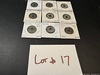 Top view showing 12 Annam coins mounted in holders with condition and date written