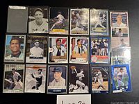 Photo of the front sides of 20 assorted baseball cards featuring various players, teams, and styles, protected in plastic sleeves.