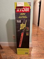 Photo of the Ryobi box showing full product details including 40V, 24 inch cordless hedge trimmer, gas-like power, 24 inch cut capacity, includes extension handle.