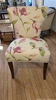 Front view of the floral upholstered accent chair showing fabric pattern, seat and legs