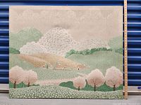 Front view of the large framed material print showing the stylized European landscape with trees, hills, clouds, and houses in muted colors.