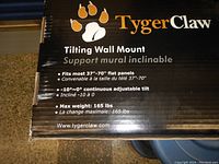 Box for Tyger Claw Tilting Wall Mount showing features and specifications including size compatibility (37-70 inches), tilt adjustment (-10° to 0°), and max weight (165 lbs).
