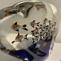 Close-up view of multiple small fish inside clear glass of the large Murano paperweight.