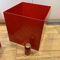 Large red plastic cube storage container showing size relative to soda can, glossy finish, good vintage condition with some surface marks and scratches.