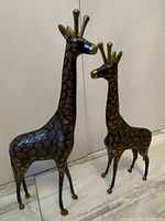 Both stylized giraffe statues side by side showing height difference and sculptural form