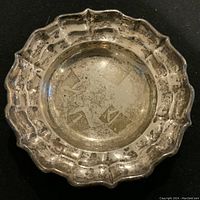 Top view of the round vintage BIRKS sterling silver bowl showing the scalloped ribbon edge and interior wear.