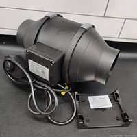 TerraBloom 4 inch inline duct fan with power cord, speed controller, on/off switch, and detachable mounting bracket placed on surface.