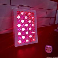 Panel powered on showing 40 red and infrared LEDs glowing with remote control on the side.