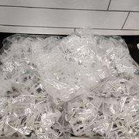 Plastic tile leveling clips in sealed plastic bags, translucent white color.