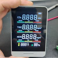 Device front screen showing metrics for CO2, TVOC, HCHO, temperature, and humidity with color-coded air quality indicators.