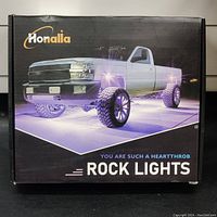Box front showing brand name 'Honalla' and image of a white pickup truck illuminated by purple light from underbody lights.