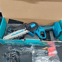 Opened box showing Peektool 8-inch cordless mini chainsaw in blue and black colors, along with a pair of gloves and other accessories in plastic.