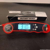 Front of digital food thermometer showing temperature reading 31.0°C with auto off button and original packaging in background.