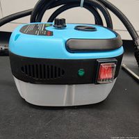 Close side view of the steam cleaner showing power switch, indicator light, and translucent water tank base.