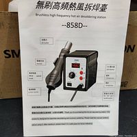 Instruction sheet showing features and functions of the 858D hot air desoldering station including air outlet, wind speed knob, power switch, LED display, temperature controls, and handle socket.