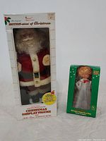 Original boxed items showing the motion Santa and angel tree topper in packaging