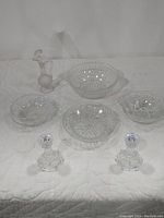 Photo showing entire collection of vintage cut glass items including decanter, bowls, candlestick holders and small cruet.