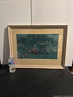 Framed print showing the full garden scene with flowers and birdbath, with a water bottle for scale.