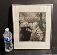 Framed black and white photograph showing the entire piece alongside a water bottle for scale. Photo highlights the frame and the artwork inside.