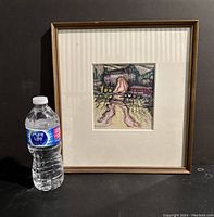 Framed artwork with water bottle for scale showing overall condition and size.