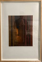 Framed photograph hung on a wall, showing full framing and matting with vertical stripes