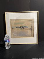 Framed watercolour painting with visible matting and frame next to a water bottle for scale, showing overall condition and size.