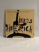 Front cover of Mary Margaret O'Hara 'Miss America' LP showing stylized album title and artist name on a beige background