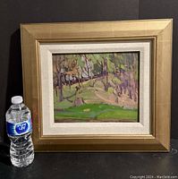 Full frontal view of framed painting with water bottle for scale