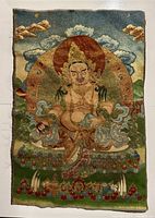 Full front view of textile thangka showing seated deity, lotus seat, halo and background