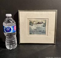 Framed print displayed next to water bottle for scale