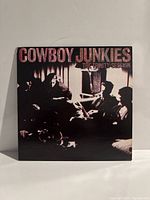 Front cover of Cowboy Junkies The Trinity Session album showing band members in monochrome setting.