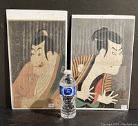 Two shrink-wrapped Ukiyo-E actor portrait woodblock prints shown next to a water bottle for scale. Each print measures 16x10 inches.