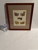 Framed vintage Deco advertisement print with water bottle for scale