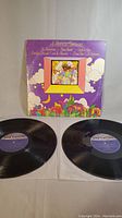 Two black vinyl records and colorful illustrated purple album cover of 'A Motown Christmas' by various artists.