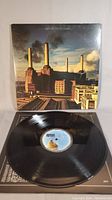 Front of the gatefold album cover showing Battersea Power Station with flying pig balloon and opened record sleeve with vinyl record.